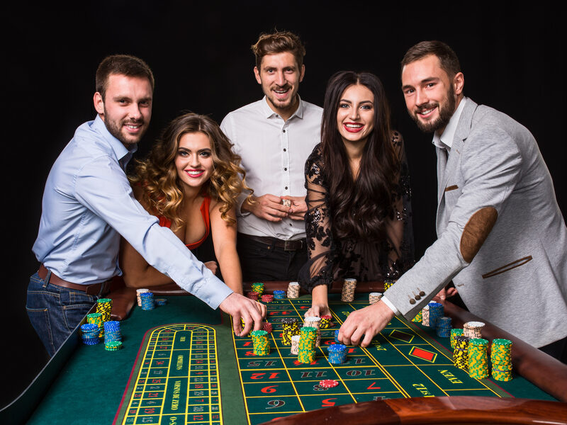Млади хора около рулетка маса